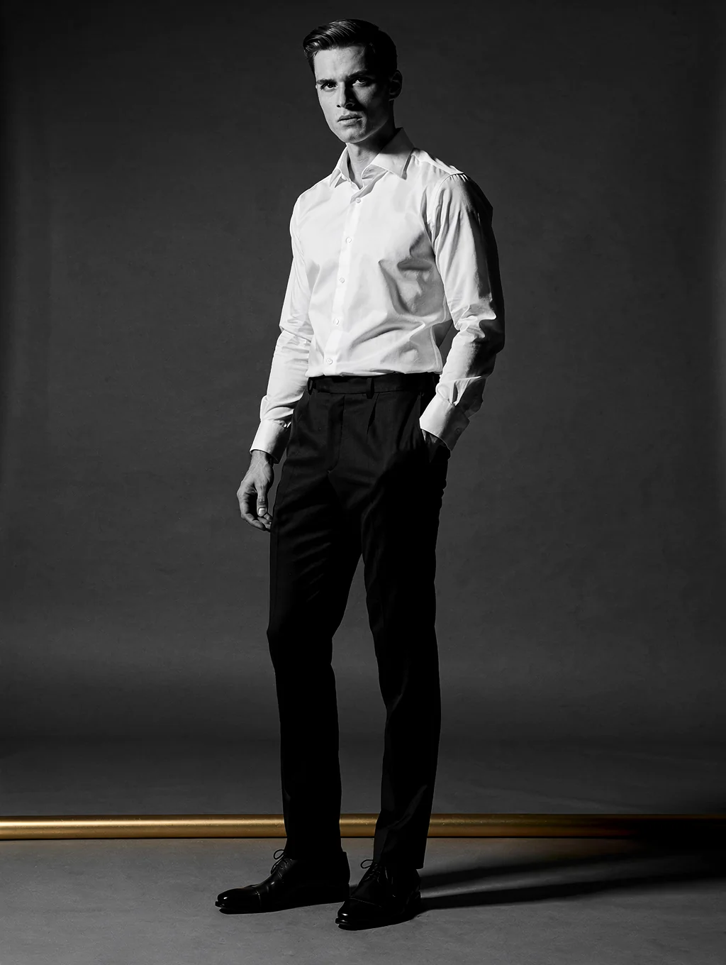High-fashion editorial portrait of Myles Dacres in a minimalist setting
